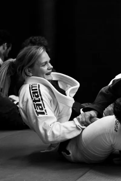 Sporter in de gi lacht tijdens de les