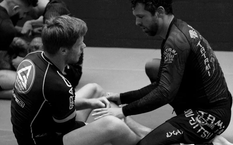 Twee sporters oefenen een leg lock